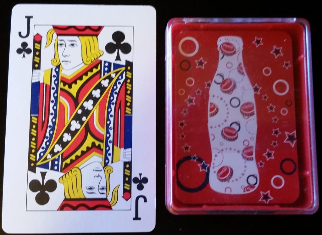 Standard sized playing card to the left showing the smaller size of the Coca-Cola® deck